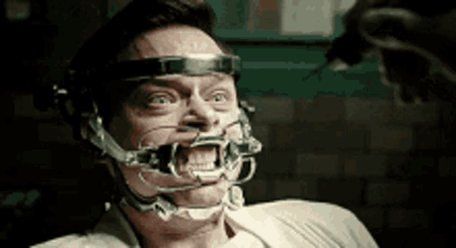 a man is sitting in a chair with a mouth guard on .
