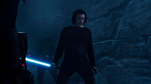 a man in a black shirt holds a blue light saber