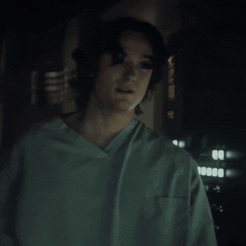 a man in a green scrub top is standing in the dark