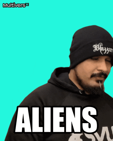 a man wearing a black beanie and a black hoodie with the word aliens on the front