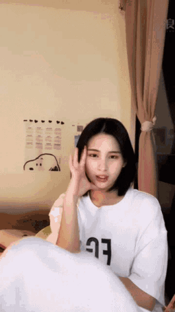 a woman wearing a white t-shirt with the letter g on it