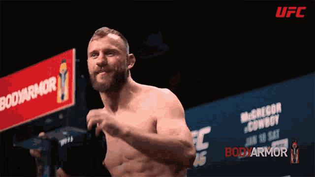 a man without a shirt is standing in front of a bodyarmor sign