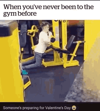 a man is kneeling down in front of a gym machine .