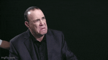 a man in a suit is making a funny face .