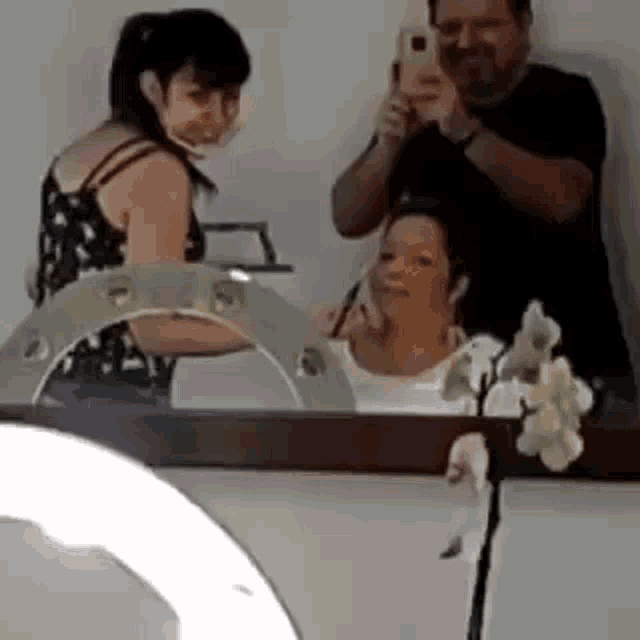 a man and a woman are taking a picture of themselves in a mirror .
