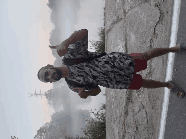 a man giving a thumbs up in front of a lake