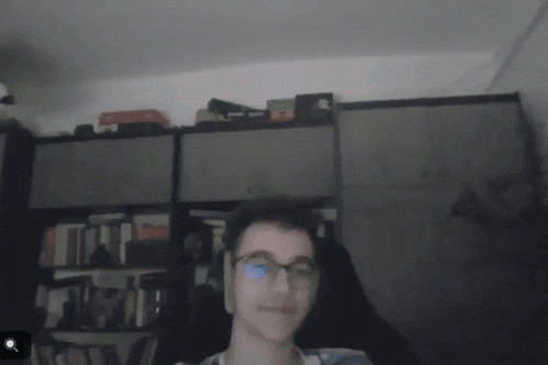 a blurry picture of a person 's face in front of bookshelves