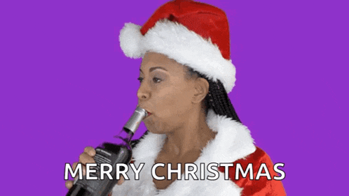a woman in a santa hat is drinking wine from a bottle