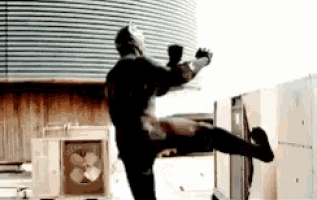 a man in a superhero costume is kicking a building .