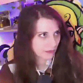 a woman with long hair is talking on a cell phone in front of a cartoon .