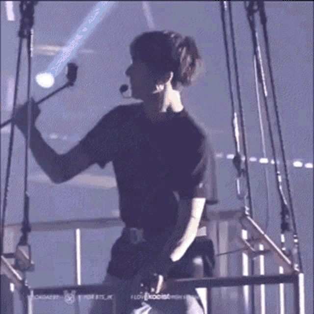 a man in a black shirt is standing in front of a microphone