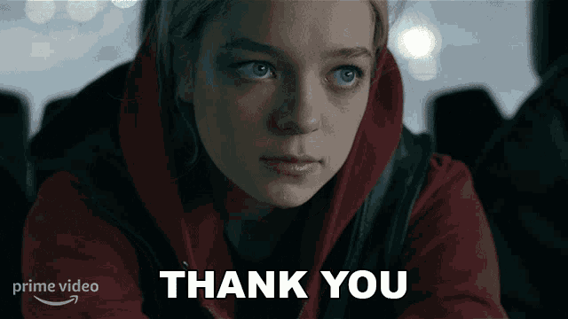 a woman in a red hoodie is looking at the camera with the words thank you behind her