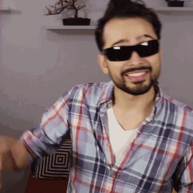 a man wearing sunglasses and a plaid shirt
