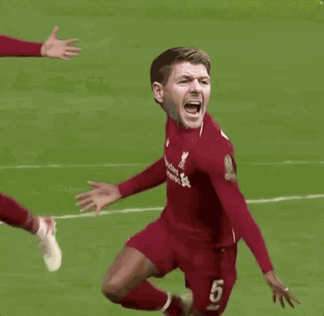 a soccer player in a red jersey with the number 14 on his shorts