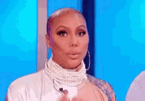 a woman is wearing a pearl necklace and hoop earrings .