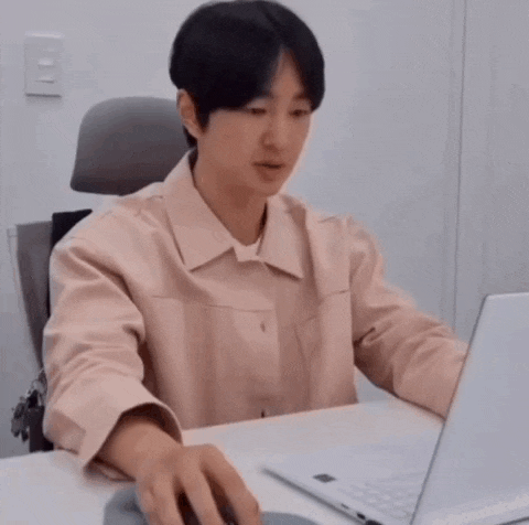 a man is sitting at a desk using a laptop computer and a mouse .