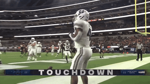 a football player stands on the field in front of a touchdown banner