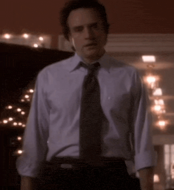 a man in a white shirt and tie is standing in a room