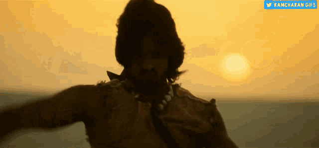 a man with a beard is dancing in front of the sun .