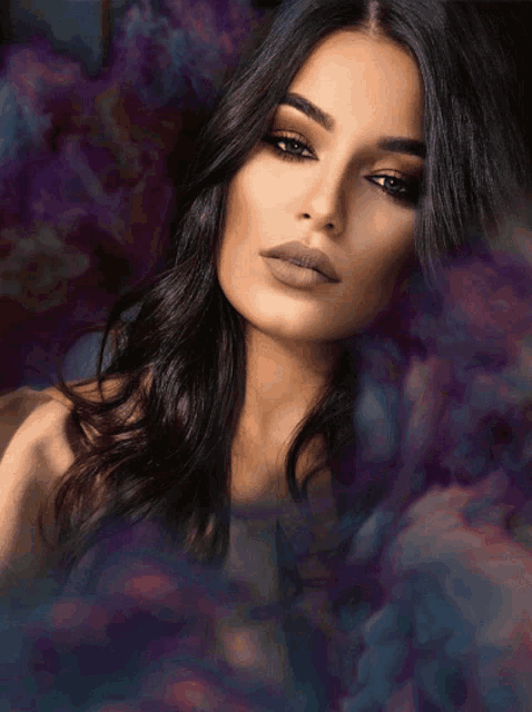 a woman with long dark hair is surrounded by smoke