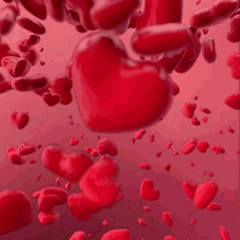 a bunch of red hearts are floating in the air .
