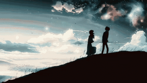 a man and a woman standing on a hill looking at each other