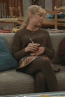 a woman sits on a couch holding a pen