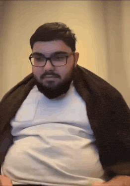 a man with glasses and a beard is wearing a white shirt and a brown jacket