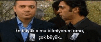 two men are standing next to each other and talking in a foreign language .