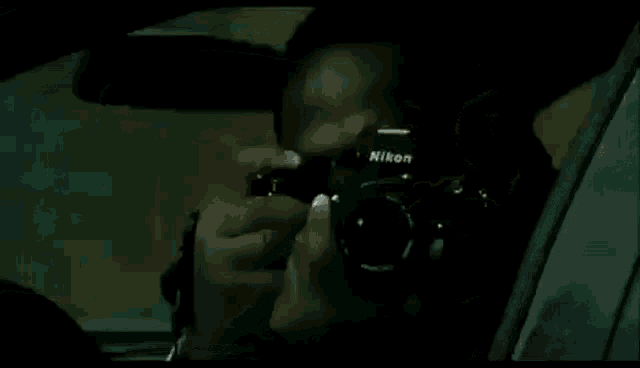 a man is sitting in the driver 's seat of a car with his mouth open .