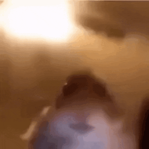 a blurred image of a person 's face with a light behind them