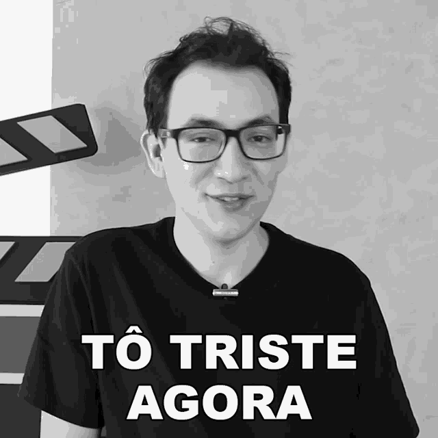 a black and white photo of a man with glasses and the words to triste agora