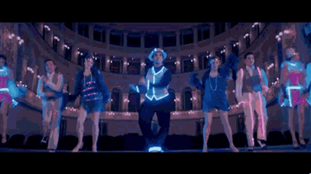 a man in a cowboy hat is dancing with a group of people