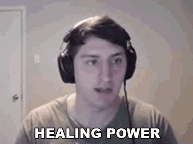 a man wearing headphones is making a funny face and saying healing power .