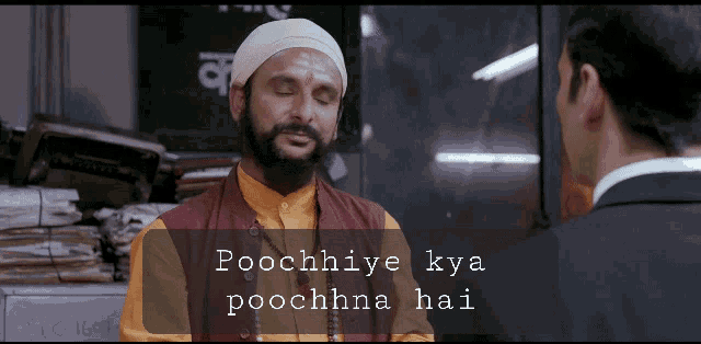a man in a turban talks to a man in a suit with the words poochniye kya poochhna hai written below him