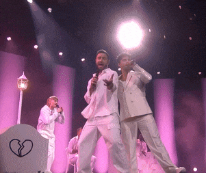 a group of men singing into microphones on a stage