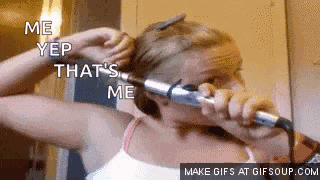 a woman is curling her hair with a curling iron and says me yep that 's me .
