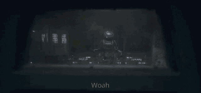 a dark room with the word woah on the bottom right