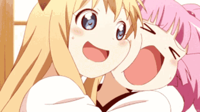 a girl with blonde hair and a pink haired girl are hugging each other