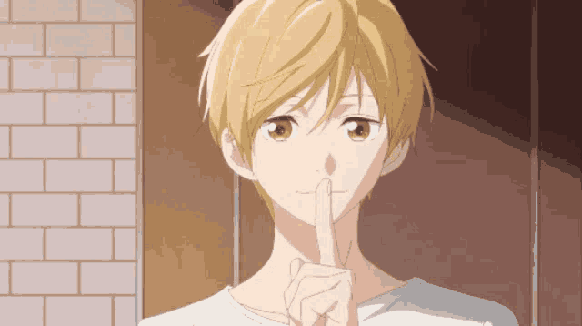 a boy with blonde hair holds his finger to his lips