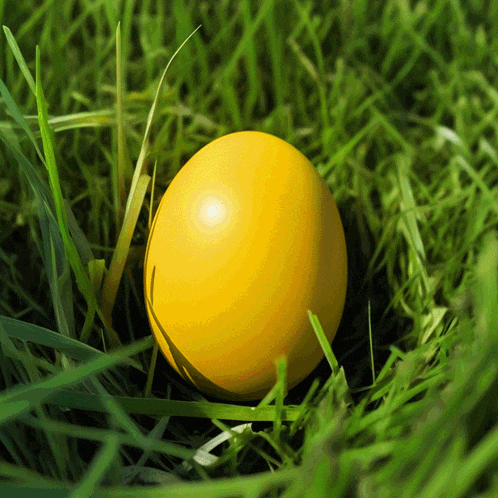a yellow egg is sitting in the grass with a green background