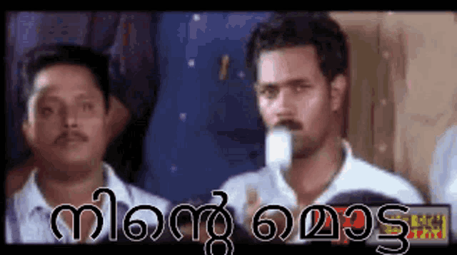 two men are standing next to each other with a foreign language written on the bottom