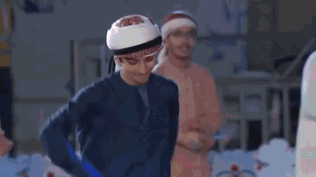 a man in a blue robe and white turban is dancing on a stage