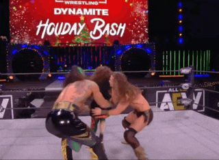 two wrestlers are wrestling in front of a sign that says holiday bash