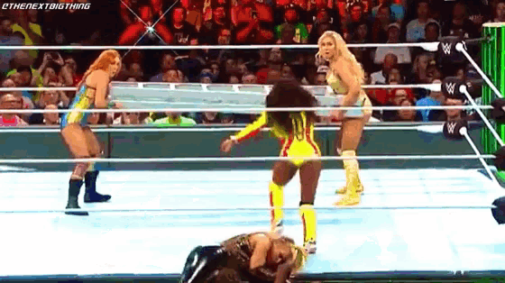 a group of women are wrestling in a wrestling ring in front of a crowd .