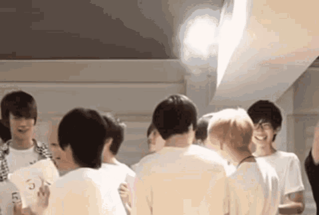 a group of young men are standing in a room and one of them has the number 5 on his shirt