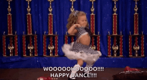 a little girl is dancing in front of trophies and says happy dance !!!