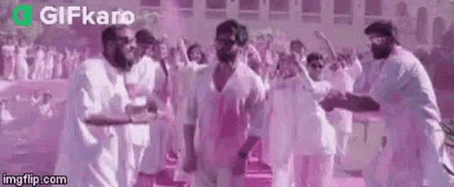 a group of men are dancing in front of a crowd of people .