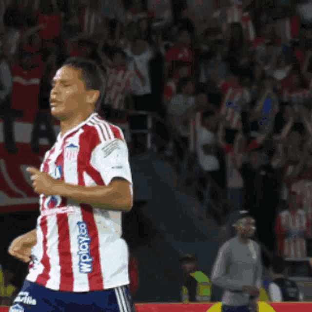 a soccer player wearing a red and white striped jersey with wploy.com on it