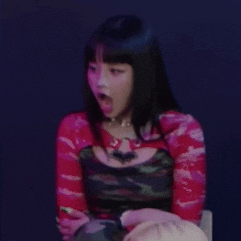 a woman with long black hair is sitting in a chair with her tongue hanging out .